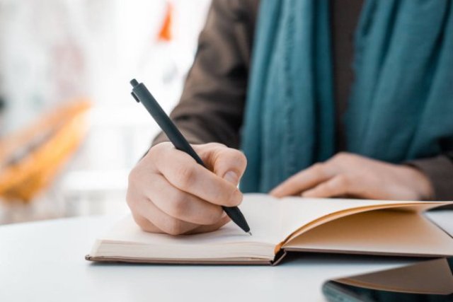 depositphotos 337890060 stock photo girl writes notebook black pen